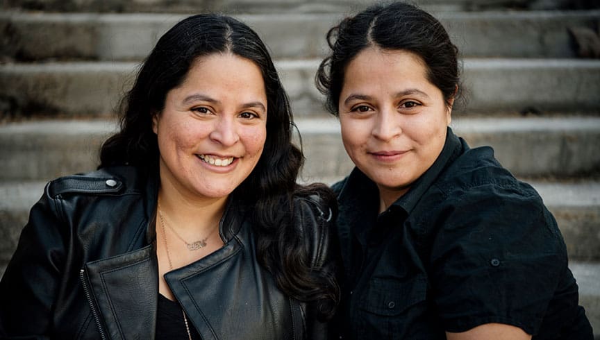 Headshot of Rennata and Georgina Lopez together. Rennata has her hair down while Georgina wears her hair up.