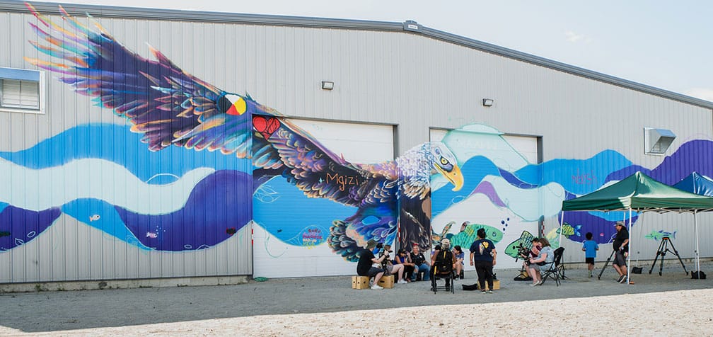 Film crew and actors of the young teens' show "Couleurs Du Nord" They are in front of a huge colourful mural of an eagle